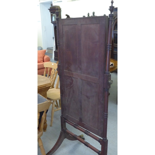 71 - A Regency mahogany cheval mirror with turned uprights, raised on splayed legs with casters  67