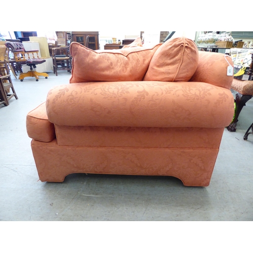 129 - A modern two person settee with a level, low back and scrolled arms, upholstered in burnt orange col... 