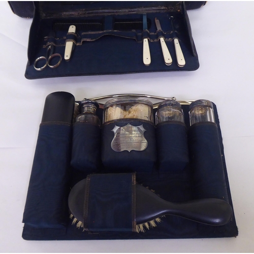 258 - An Edwardian Gladstone style vanity case, containing some silver topped receptacles  marks rubbed