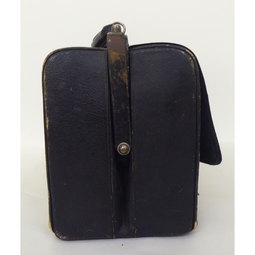 258 - An Edwardian Gladstone style vanity case, containing some silver topped receptacles  marks rubbed