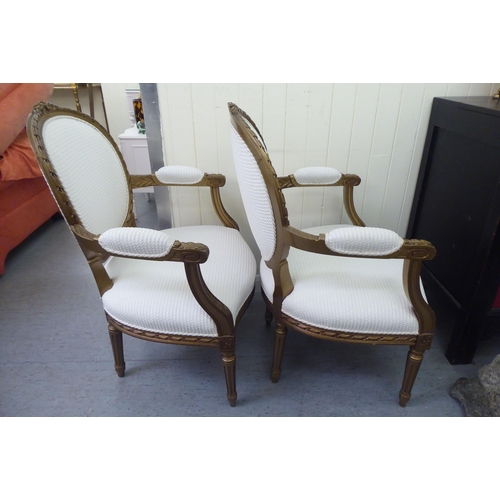 326 - A pair of modern Louis XVI design, stained beech framed salon chairs upholstered in cream coloured f... 