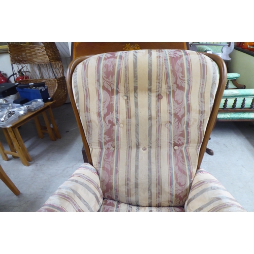 105 - A Ercol beech framed high spindled back armchair, raised on elliptically turned legs