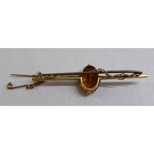 11 - Two late Victorian yellow metal bar brooches, each set with a coloured stone 