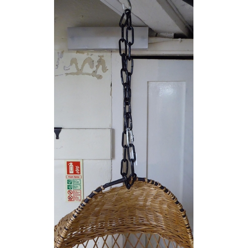 115 - A metal framed and woven cane 'Egg' hanging chair, on chain