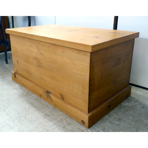 124 - A modern pine chest with straight sides and a hinged lid, on a plinth  19