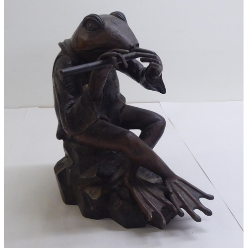 14 - A patinated cast bronze model, a frog seated on a rock, playing a flute  11