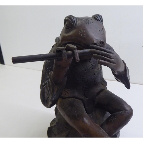 14 - A patinated cast bronze model, a frog seated on a rock, playing a flute  11