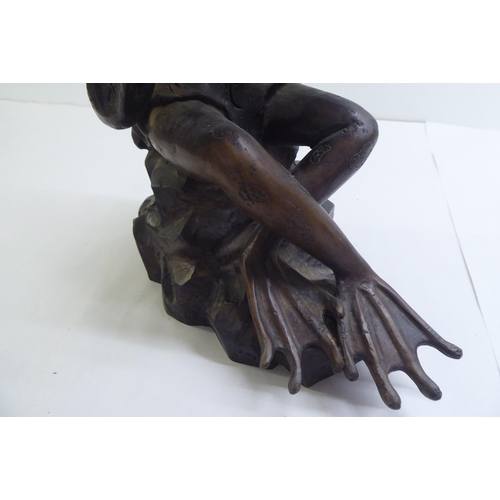 14 - A patinated cast bronze model, a frog seated on a rock, playing a flute  11