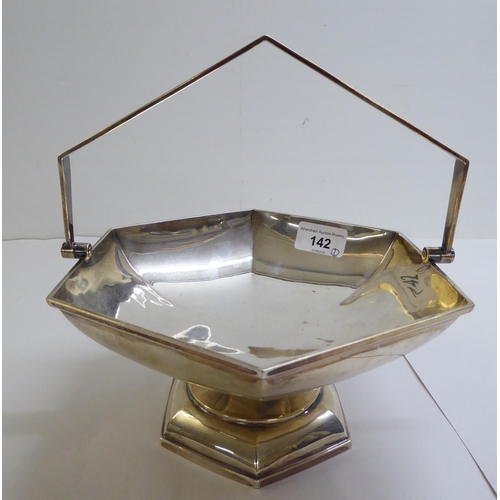 142 - A silver fruit basket of octagonal, pedestal design with a swing top handle  Sheffield 1923&nbs... 