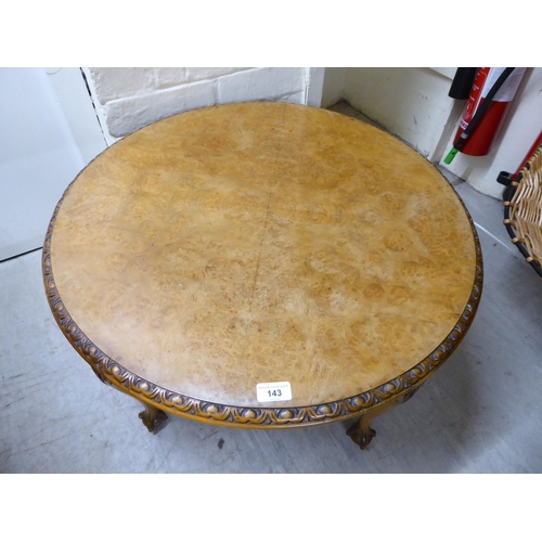 143 - A 1930s walnut coffee table, the top with a piecrust edge, raised on cabriole legs, talon and ball f... 