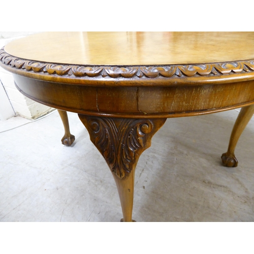 143 - A 1930s walnut coffee table, the top with a piecrust edge, raised on cabriole legs, talon and ball f... 