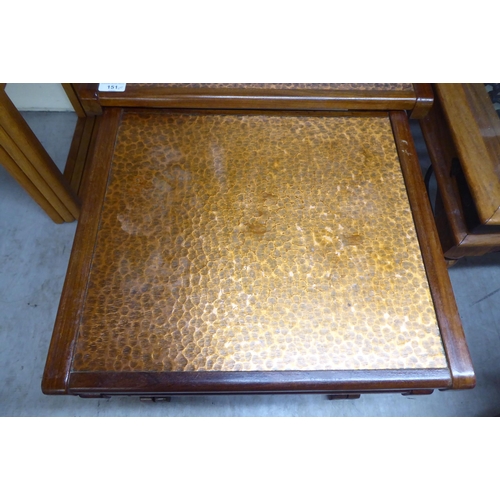 151 - A (probably G-Plan) nesting set of three teak framed tables, the tops set with a spot-hammered coppe... 