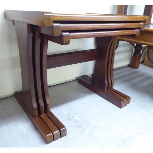 151 - A (probably G-Plan) nesting set of three teak framed tables, the tops set with a spot-hammered coppe... 