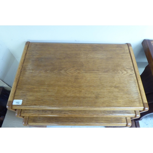 152 - A nesting set of three Preben Schou of Denmark light oak occasional tables, on a splayed underframe ... 