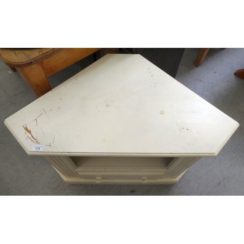 174 - A modern white painted pine corner television stand, having an open shelf and one drawer, on a plint... 