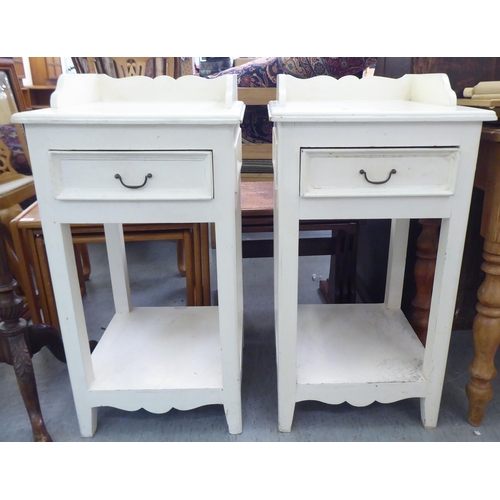 175 - A pair of modern white painted, wooden bedside cupboards, the galleried top over a single drawer, ra... 