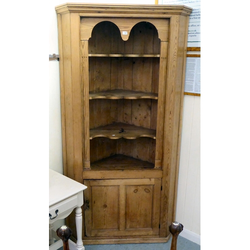 192 - An early 20thC pine corner cupboard, accommodating four open shelves, over a single door, on a plint... 