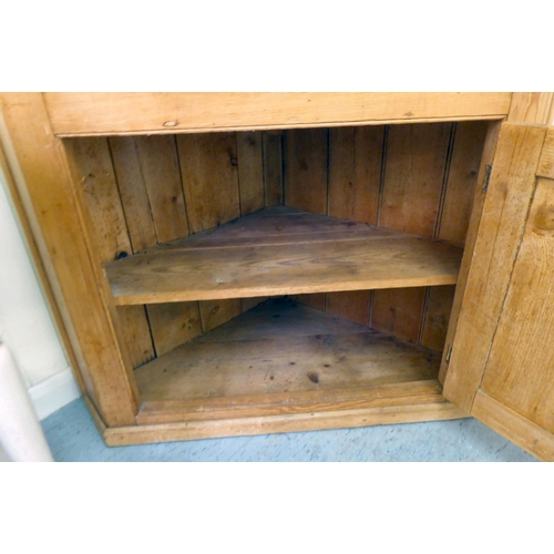 192 - An early 20thC pine corner cupboard, accommodating four open shelves, over a single door, on a plint... 