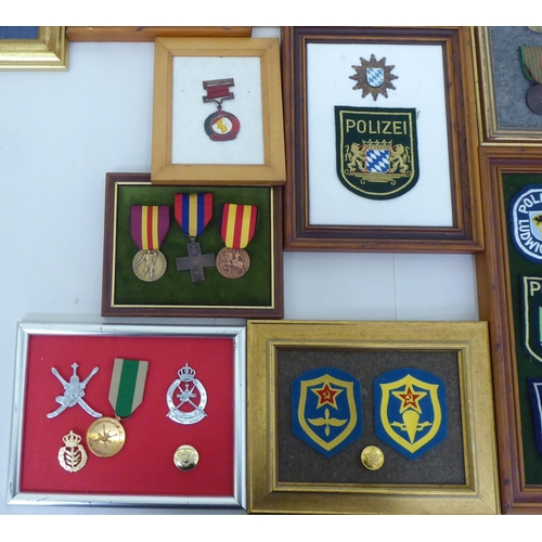 254 - Framed replica medals, awards and buttons: to include World War II examples  largest 14.5