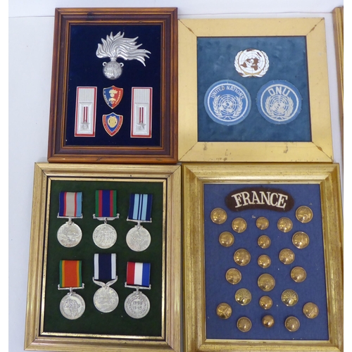 254 - Framed replica medals, awards and buttons: to include World War II examples  largest 14.5