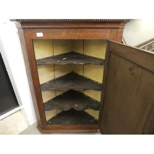 272 - A mid 19thC oak hanging corner cabinet, the hinged door inlaid with a flowering vase design, enclosi... 