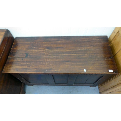 277 - A late 18thC oak coffer with a hinged lid and a tri-panelled front, raised on block feet  28