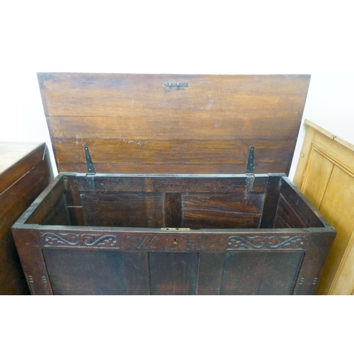 277 - A late 18thC oak coffer with a hinged lid and a tri-panelled front, raised on block feet  28