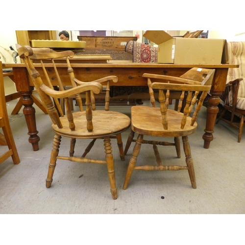 281 - An early 20thC beech framed captain's chair, the tapered bar back over a circular seat, raised on tu... 