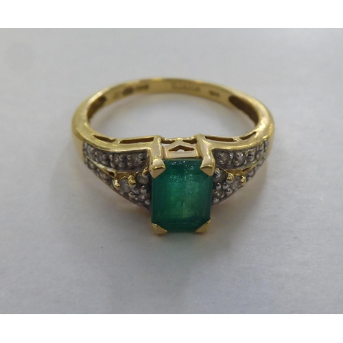 297 - An 18ct gold ring, set with a central octagon cut emerald, flanked by diamonds