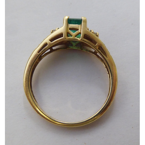 297 - An 18ct gold ring, set with a central octagon cut emerald, flanked by diamonds