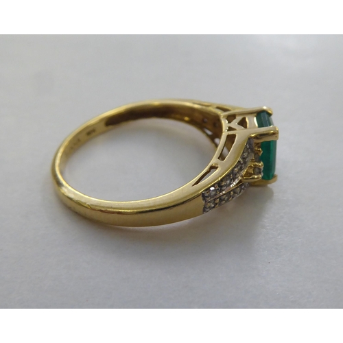 297 - An 18ct gold ring, set with a central octagon cut emerald, flanked by diamonds