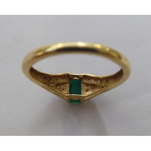 297 - An 18ct gold ring, set with a central octagon cut emerald, flanked by diamonds