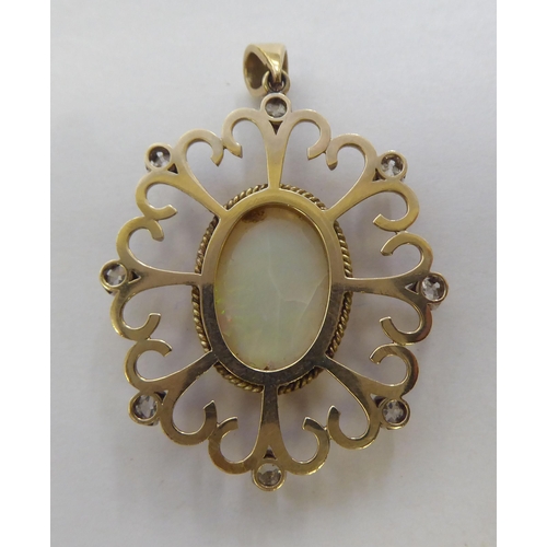 299 - A yellow metal pendant, set with a central cabochon opal, surrounded with round cut diamonds