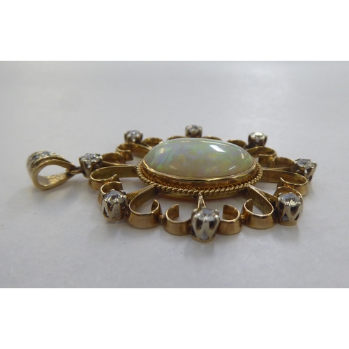 299 - A yellow metal pendant, set with a central cabochon opal, surrounded with round cut diamonds