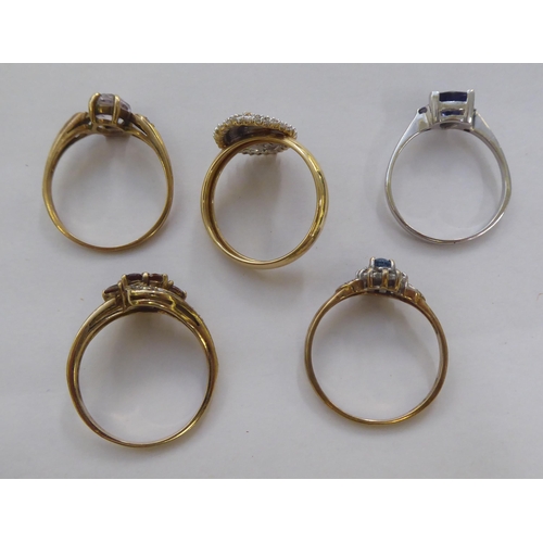 300 - Five 9ct gold dress rings: to include a cluster ring, set with a central blue stone, surrounded by d... 