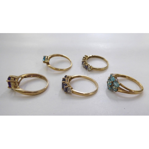 304 - Five 9ct gold dress rings: to include a crossover ring with a blue stone