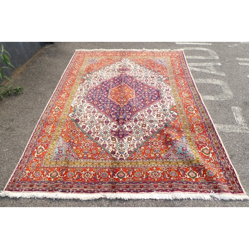 313 - A Persian rug with stylised motifs, on a red ground  111