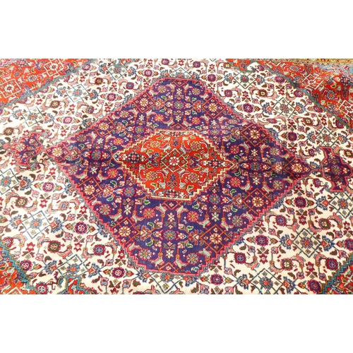 313 - A Persian rug with stylised motifs, on a red ground  111