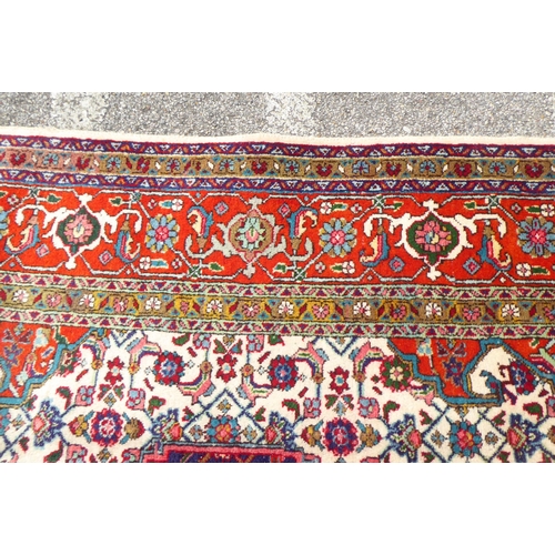 313 - A Persian rug with stylised motifs, on a red ground  111