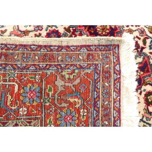 313 - A Persian rug with stylised motifs, on a red ground  111