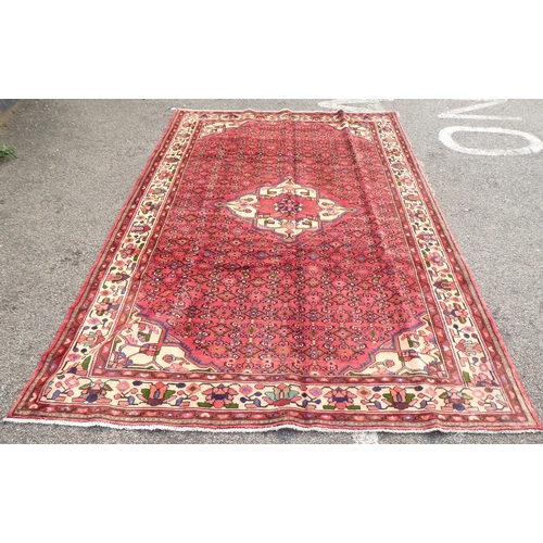 314 - A Persian rug with a central gul, on a red ground  115