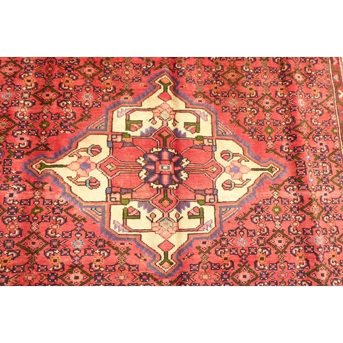 314 - A Persian rug with a central gul, on a red ground  115