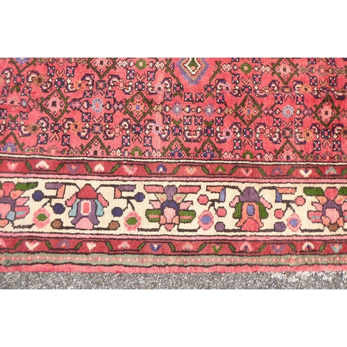 314 - A Persian rug with a central gul, on a red ground  115