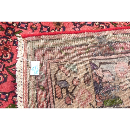 314 - A Persian rug with a central gul, on a red ground  115