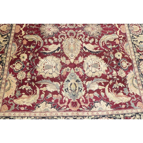 315 - A Persian rug with floral motifs, on a brown and green ground  115