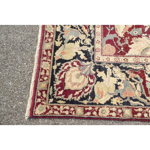 315 - A Persian rug with floral motifs, on a brown and green ground  115