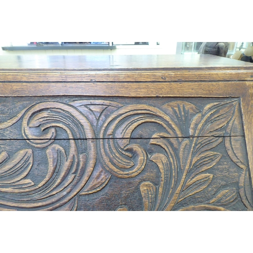 316 - An early 20thC carved oak bureau, the fall front over four long drawers, on a plinth  40.5