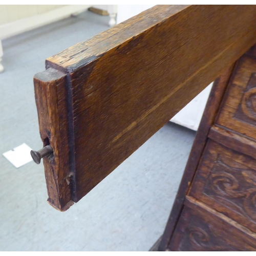 316 - An early 20thC carved oak bureau, the fall front over four long drawers, on a plinth  40.5