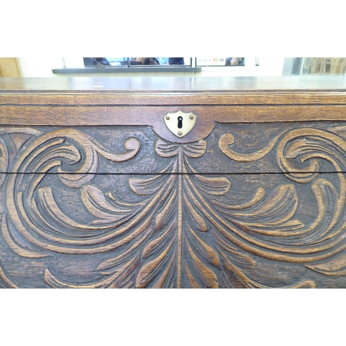 316 - An early 20thC carved oak bureau, the fall front over four long drawers, on a plinth  40.5