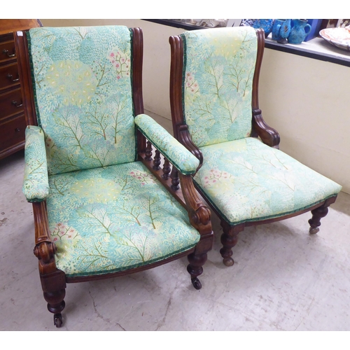 5 - Two matched Edwardian mahogany showwood framed salon chairs, later stud upholstered in floral patter... 